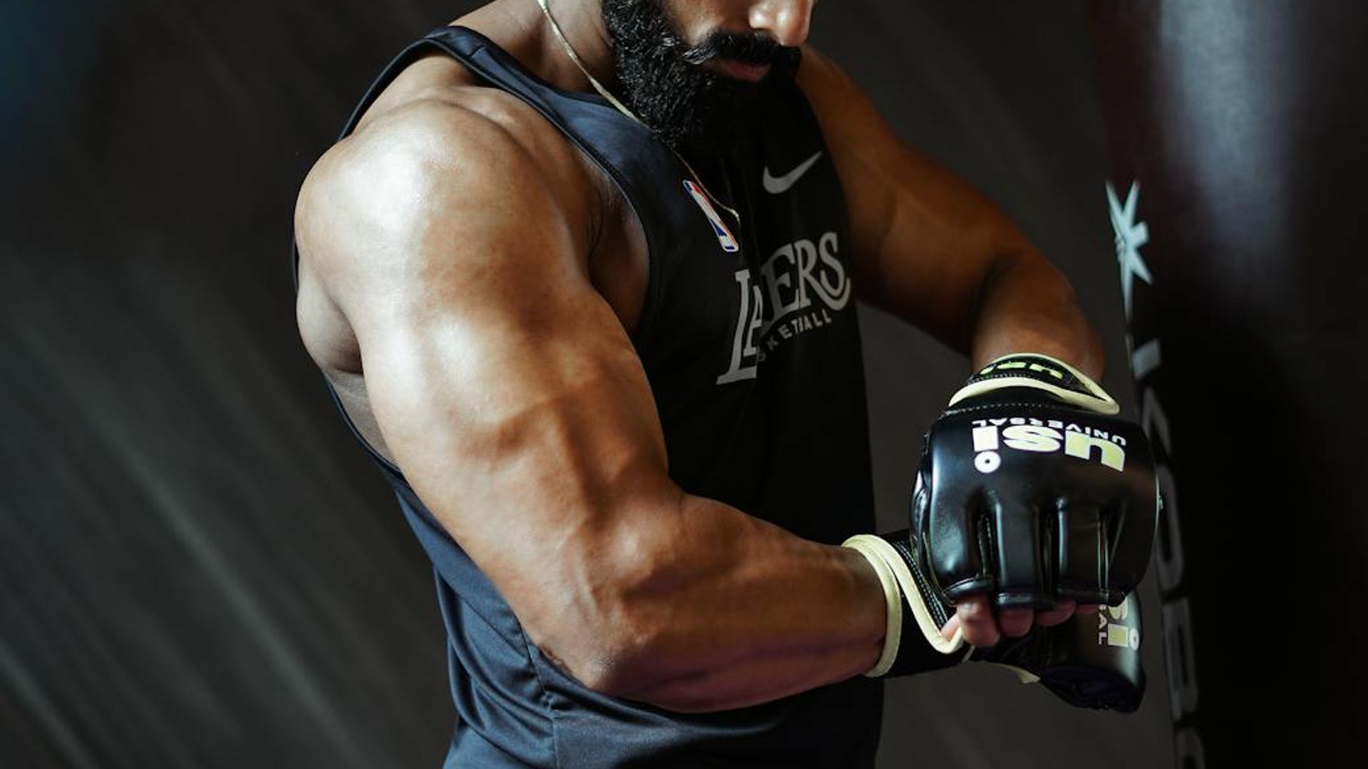 Man in a calm, focused stance in a minimalist gym setting.